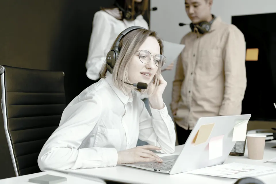 Agente de atención trabajando con auriculares y una computadora
